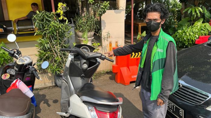 Ahmad Robiansyah (26) driver ojek online (ojol) menunjukkan sepeda motornya di Mapolsek Palmerah, Palmerah, Jakarta Barat pada Senin (22/9/2025).