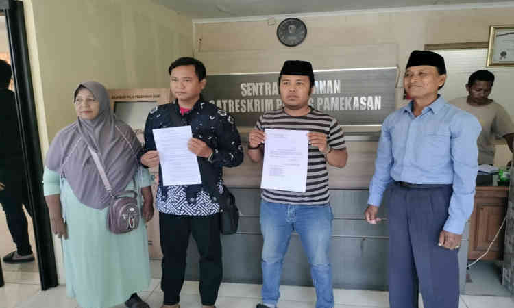 Warga Desa Larangan Tokol, Kecamatan Tlanakan, Pamekasan, saat menunjukkan surat laporan polisi terkait dugaan kasus pengrusakan rumah di Mapolres Pamekasan, Rabu (11/9/2025).