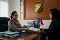 Foto ilustrasi: Seorang warga menyerahkan berkas pengaduan kepada anggota polisi di ruang pelayanan kantor kepolisian.
