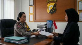 Foto ilustrasi: Seorang warga menyerahkan berkas pengaduan kepada anggota polisi di ruang pelayanan kantor kepolisian.