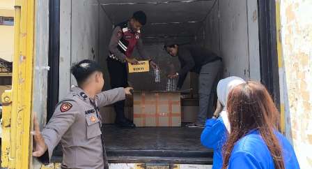 Petugas Polresta Banyuwangi saat mengamankan truk box bermuatan ribuan botol arak di kawasan Kalipuro, Kamis (9/10/2025) dini hari.