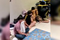 Petugas kepolisian saat mengamankan puluhan pria dalam penggerebekan pesta terlarang di salah satu hotel kawasan Surabaya, Minggu dini hari (19/10/2025).