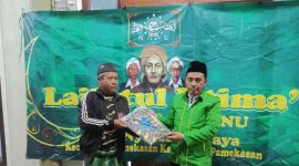 Penyerahan seragam Banser secara simbolis kepada anggota Banser Nyalabu Daya.