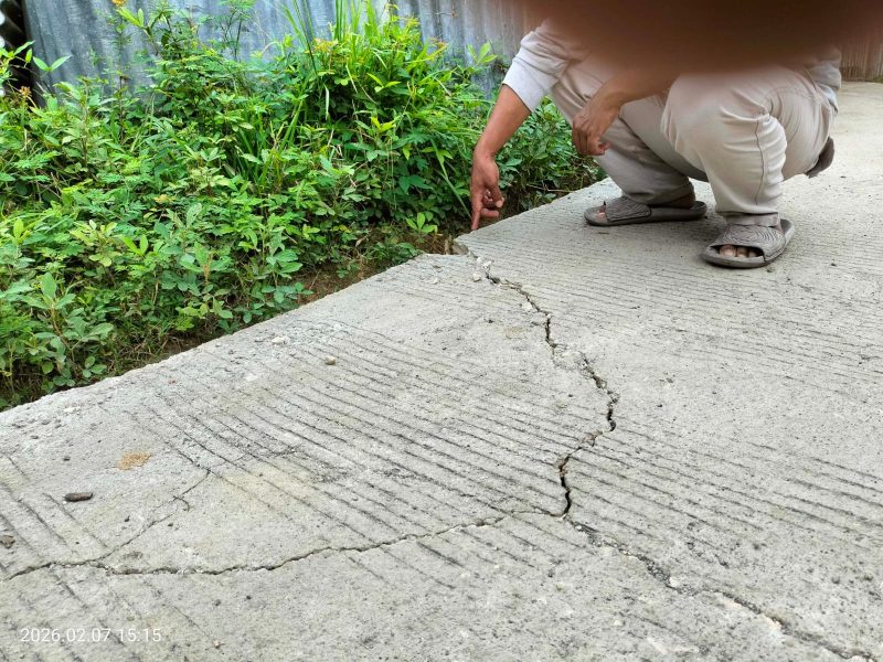 Caption: Wartawan saat Monitoring ke Lokasi dan Menunjukkan Kondisi Kerusakan Proyek Rabat Beton di Desa Mambulu Barat (Sumber Foto: Jatimzone.com)