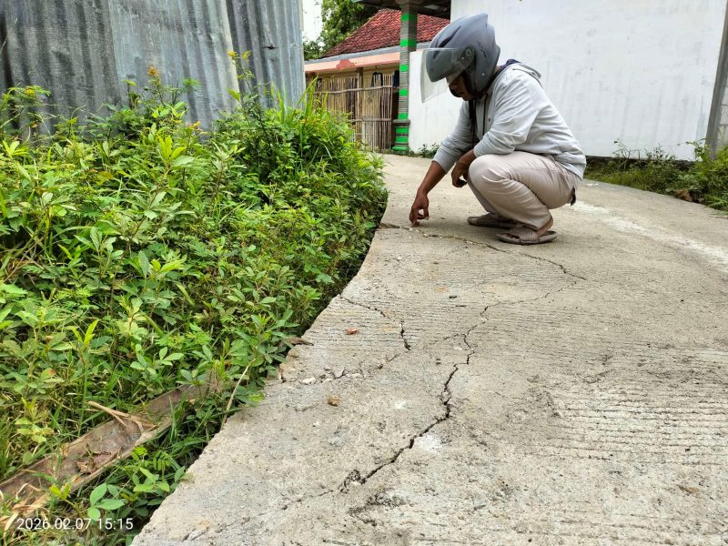 Caption: Wartawan saat Menunjukkan Kondisi Kerusakan Proyek Rabat Beton di Desa Mambulu Barat, Dusun Burnang, Dana Desa Tahun Anggaran 2025 (Sumber Foto: Jatimzone.com)
