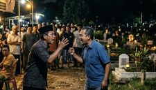ilustrasi dua orang Cekcok di Tengah Acara Warga di area pemakaman pada saat malam hari.