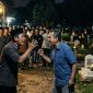 ilustrasi dua orang Cekcok di Tengah Acara Warga di area pemakaman pada saat malam hari.